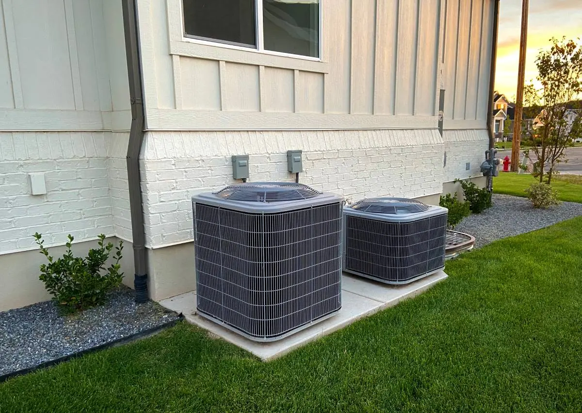 an HVAC system outside a home in a suburban neighborhood with freshly cut green grass
