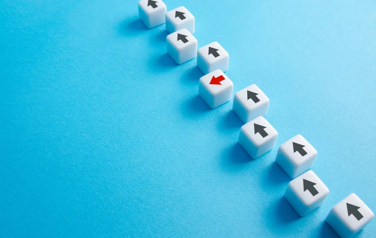 dice with arrows on them, all black arrows pointing in the same direction except for one red arrow pointing to the left, against a blue background