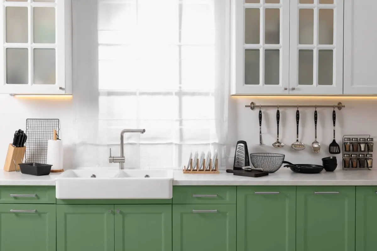bright kitchen with green lower cabinets and white upper cabinets