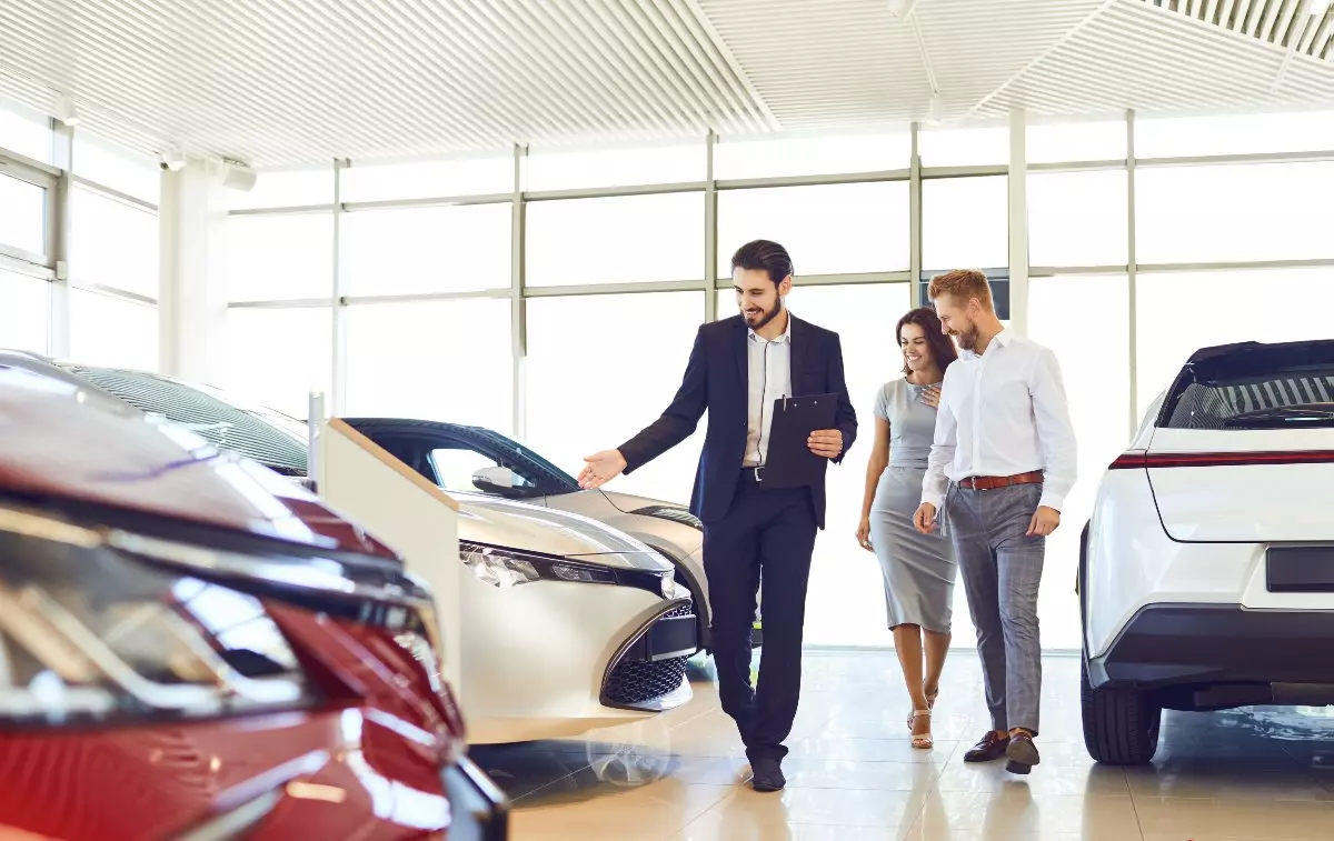 Car salesperson showing car models to consumers 