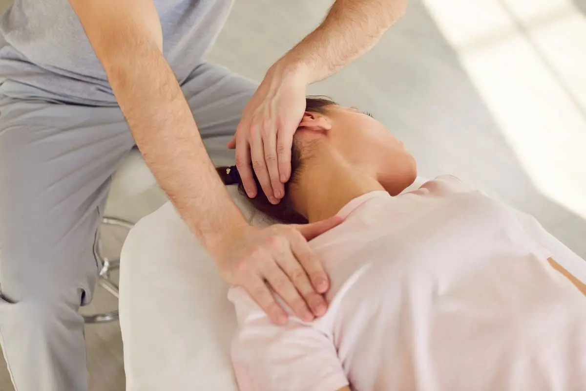 a woman in a pink shirt receiving patient care at a chiropractic practice