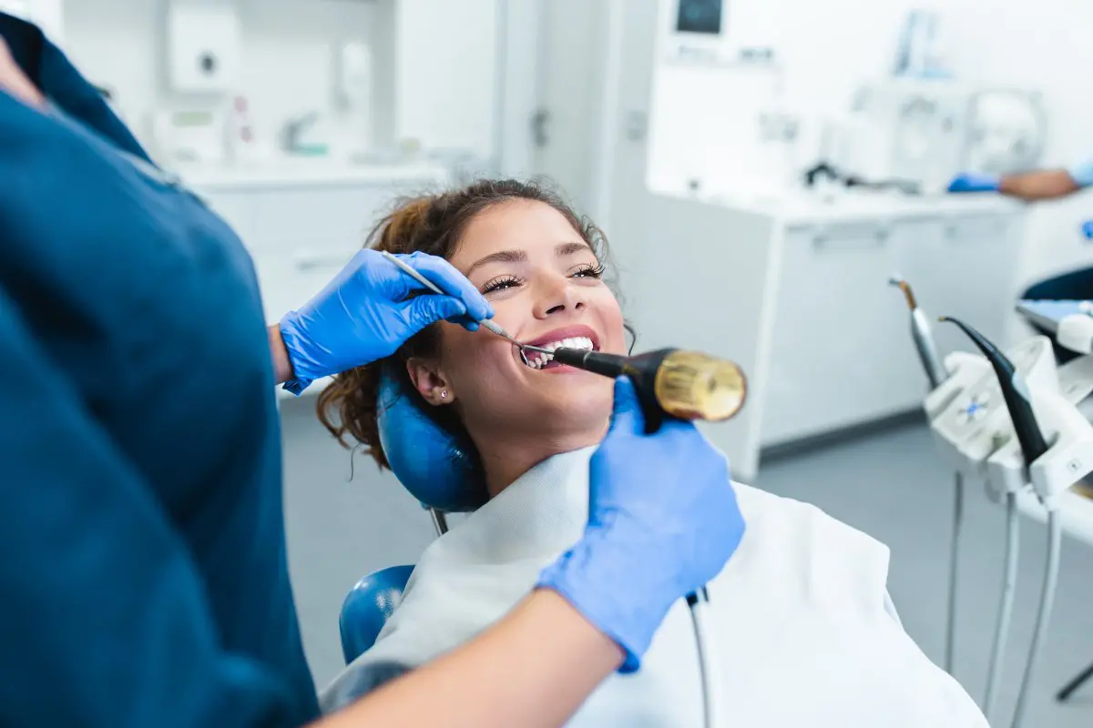 Dental technician whitening client's teeth