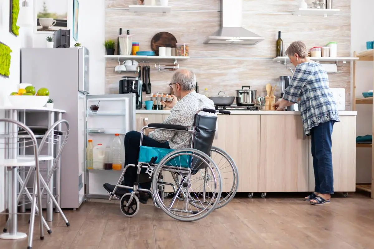an elderly couple, man in a wheelchair, using their accessible kitchen