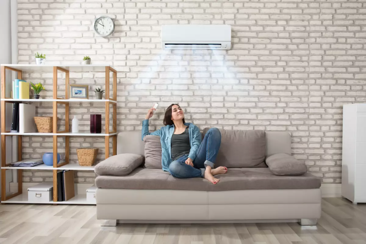 Young adult sitting on couch enjoying HVAC system