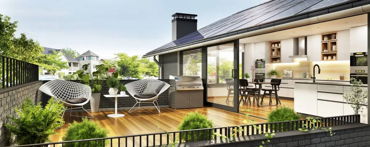 an open concept kitchen that opens up to a balcony with a grill and greenery 