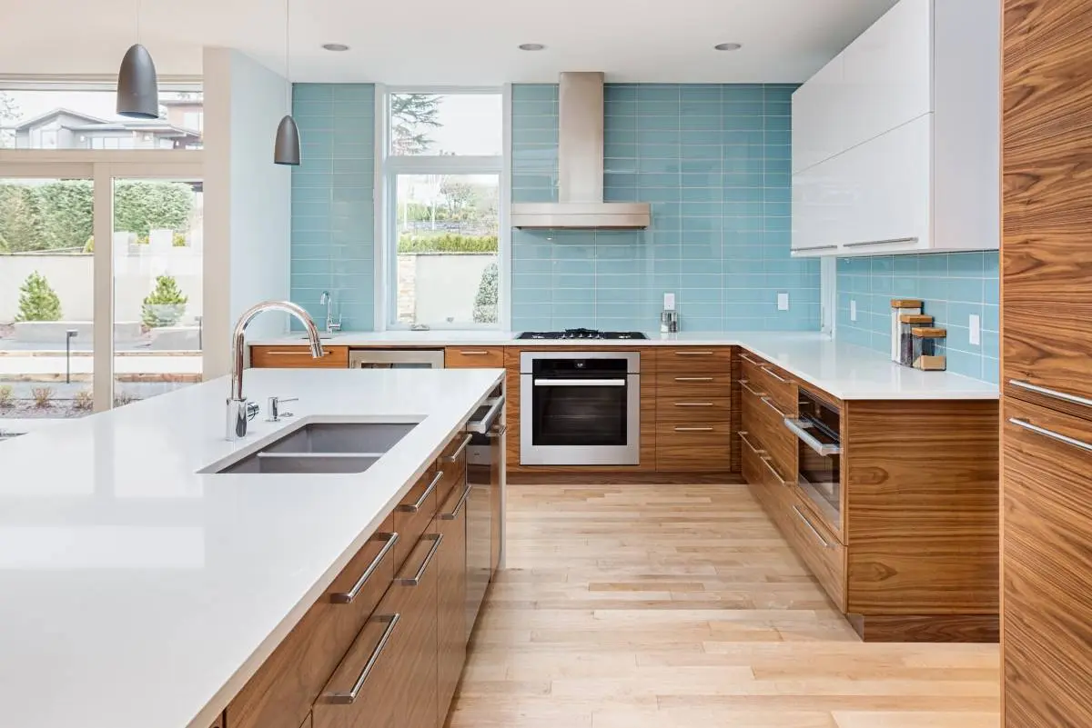 a kitchen with warm, wooden lower cabinets and a cool blue backsplash 