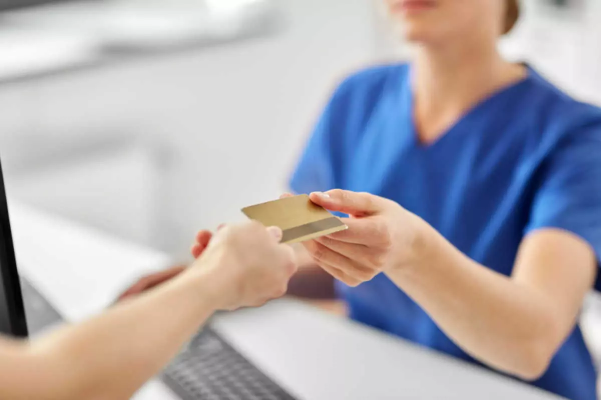 Close up on patient handing credit card to nurse 