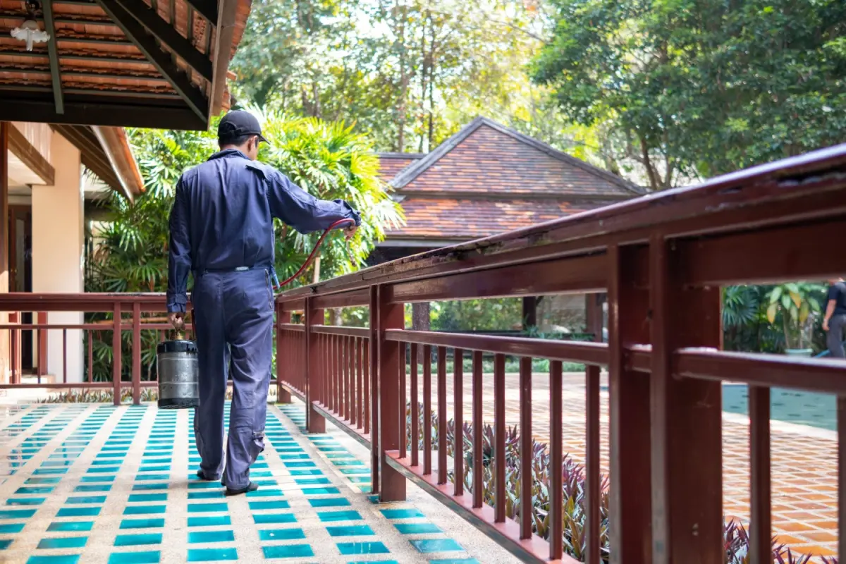 Pest control team member spraying a structure