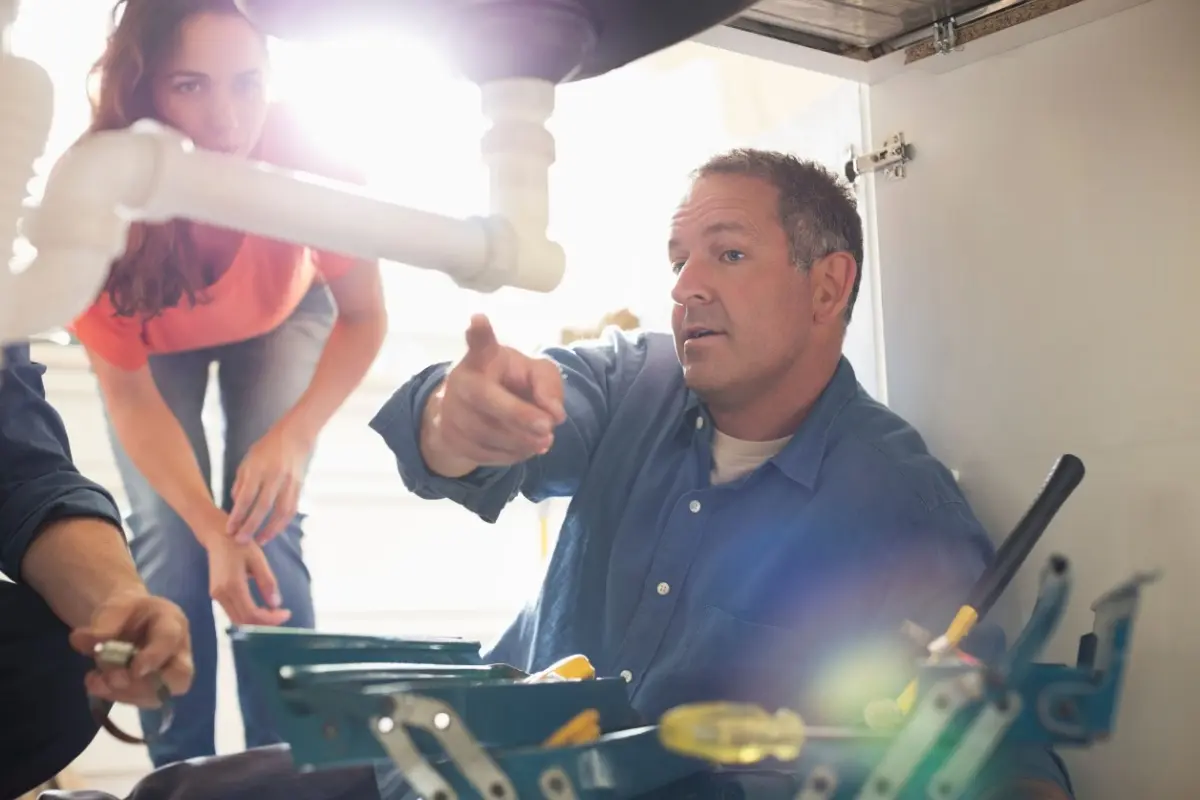 Plumber practicing good customer service with client.