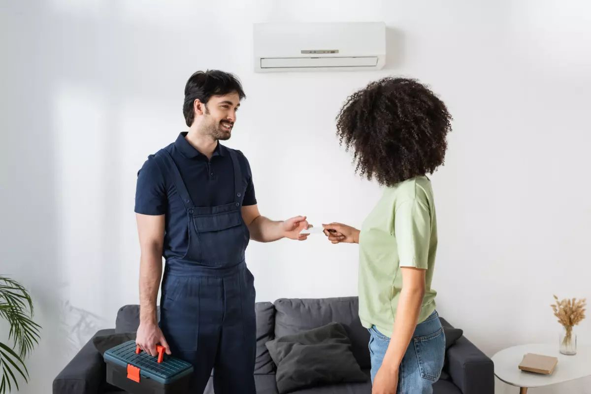 Repairman handing business card to client 