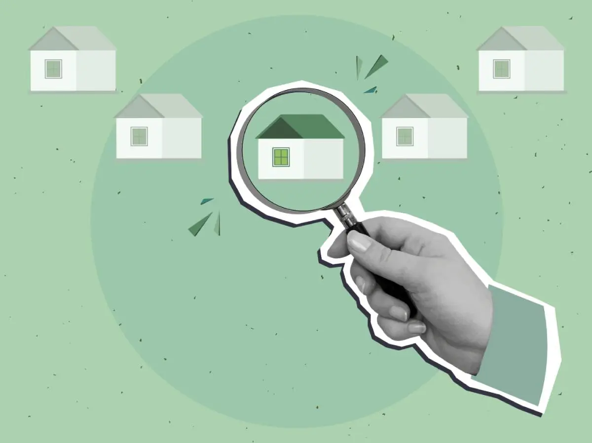 a hand holding a magnifying glass over a house with a green roof as seen at roofing trade shows in 2026