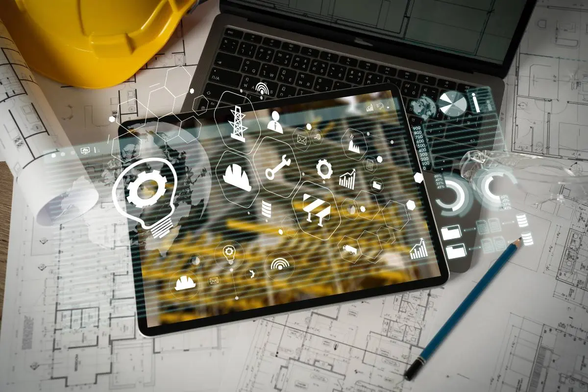 a hard hat, blueprints, pencil, laptop, and tablet on a table with icons from contractor software floating above